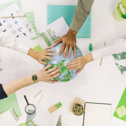 group-businesspeople-placing-their-hands-globe